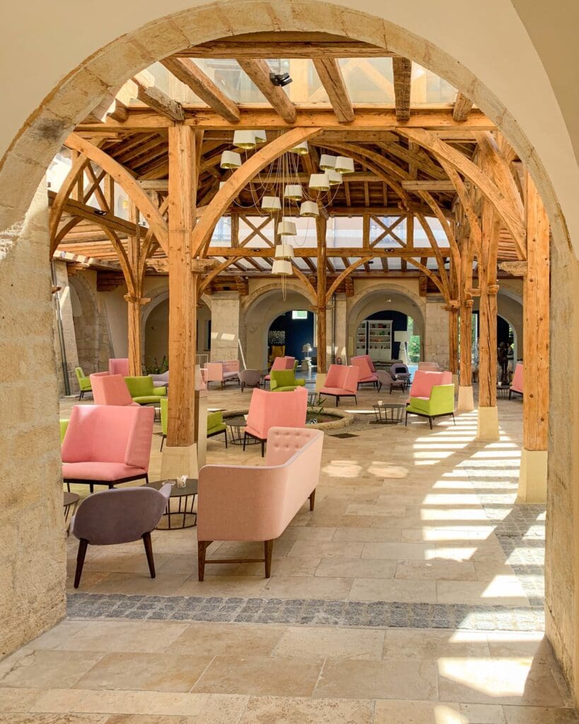 A beautiful indoor/outdoor space full of pink seating areas at Couvent des Minimes Provence 